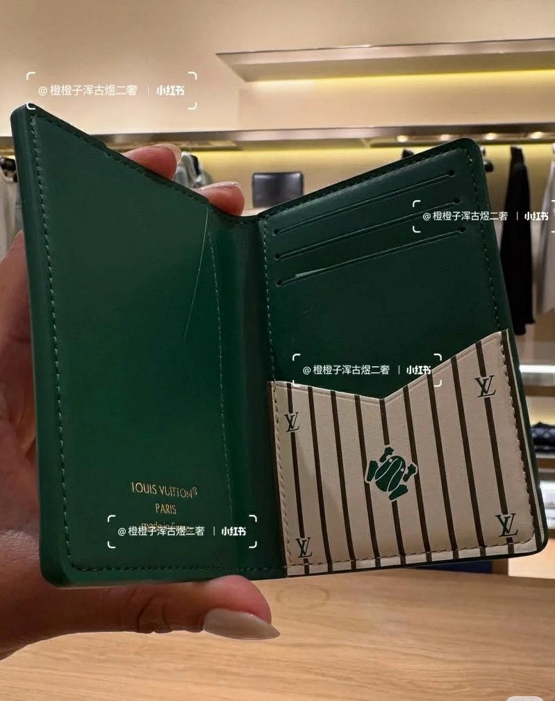 Small Louis Vuitton card holder, green, open with striped center panel and emblem