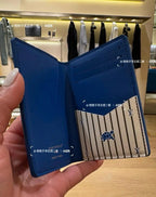 Small Louis Vuitton card holder, blue, open with striped center panel and emblem
