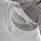 Moncler white crewneck T-shirt neckline with inner brand label, close-up