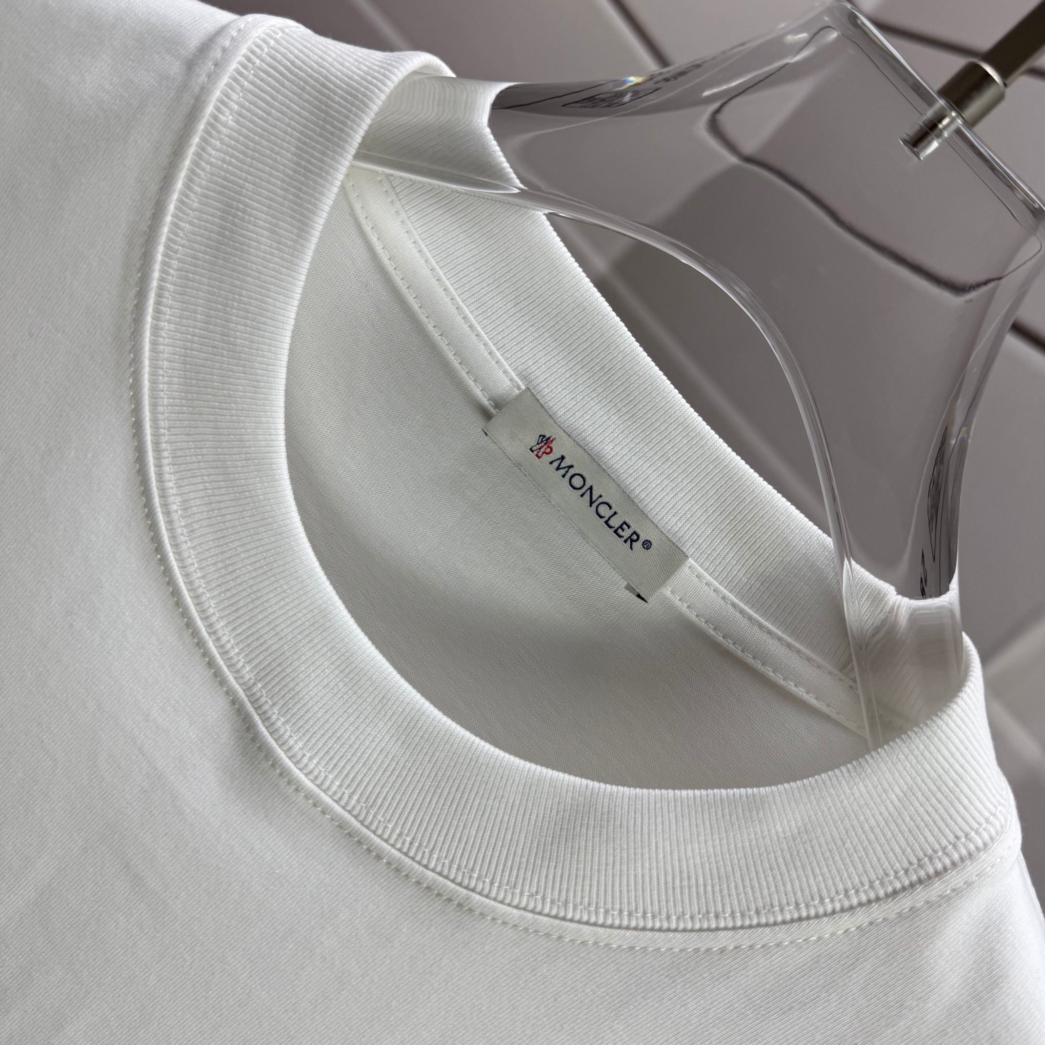 Moncler white crewneck T-shirt neckline with inner brand label, close-up