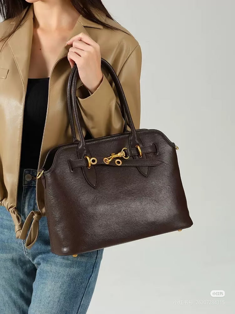 MiuMiu leather tote bag in dark brown with gold clasp and front logo tag on person