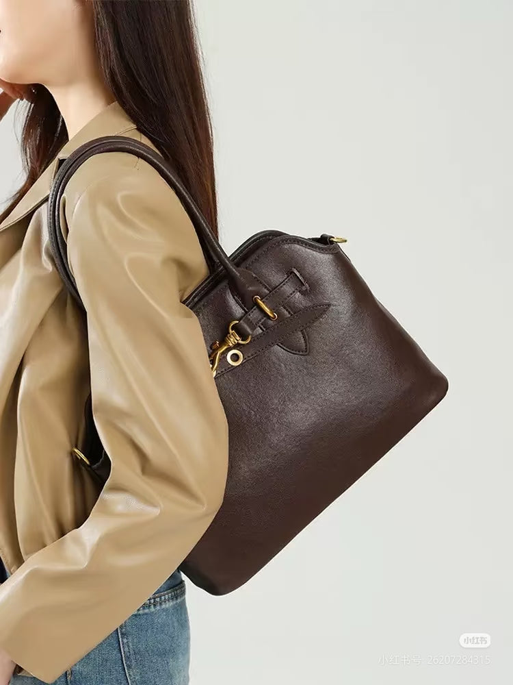 MiuMiu leather tote bag in dark brown, side view with gold hardware and top handles
