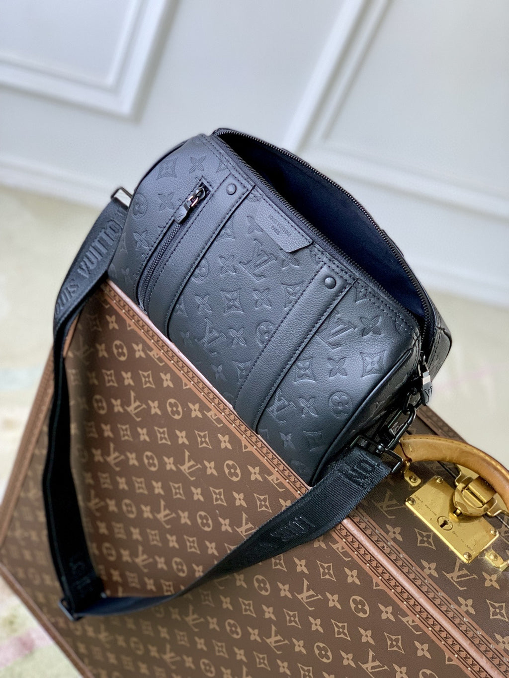 Louis Vuitton men’s crossbody bag with dark blue monogram panel and gold clasp
