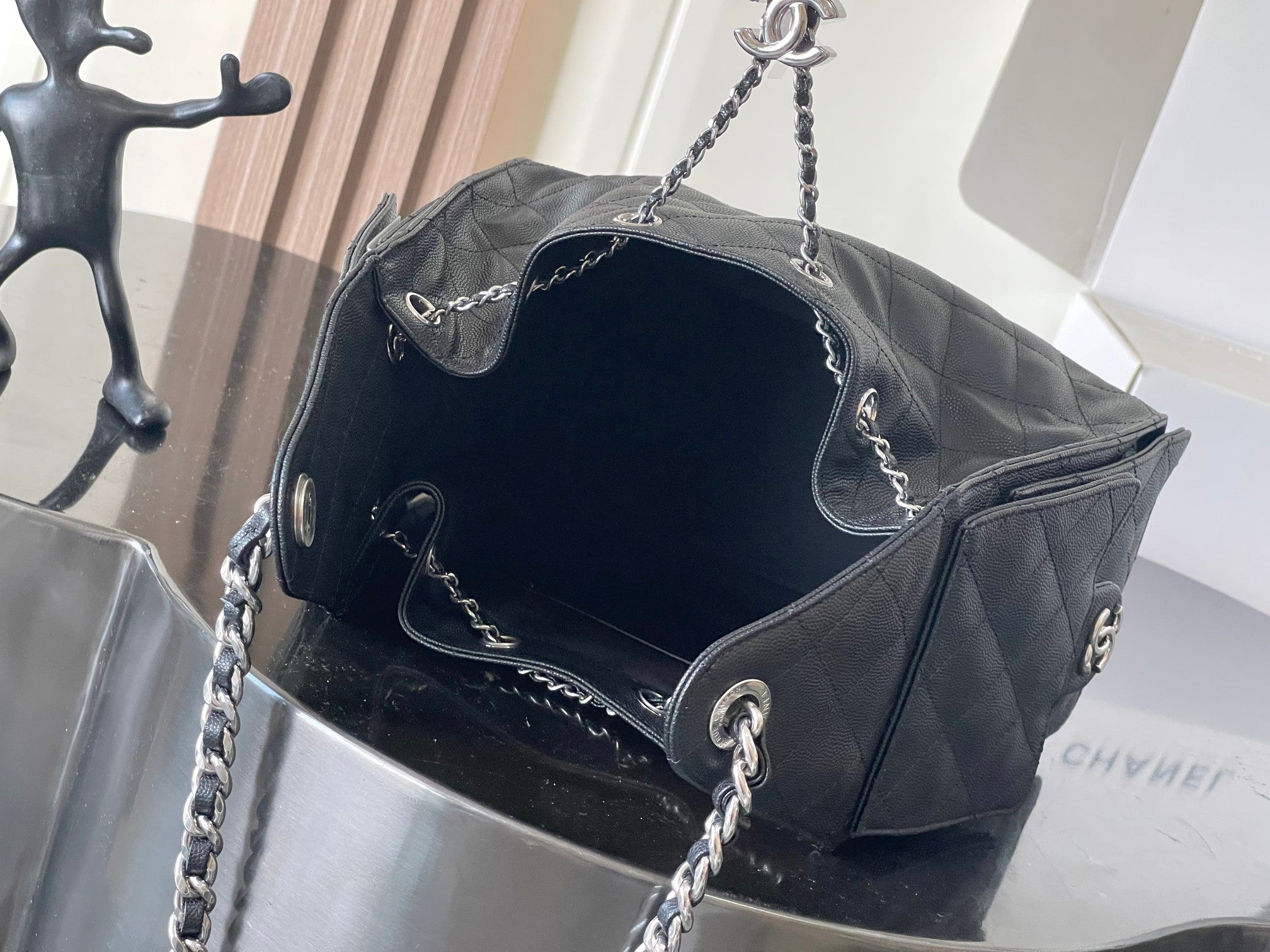 Chanel quilted bag with chain strap, open top showing dark fabric lining