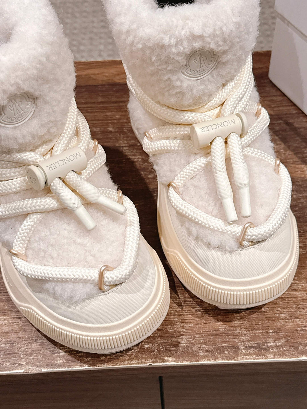 Moncler cream shearling lace-up boots, close-up of laces and logo medallion