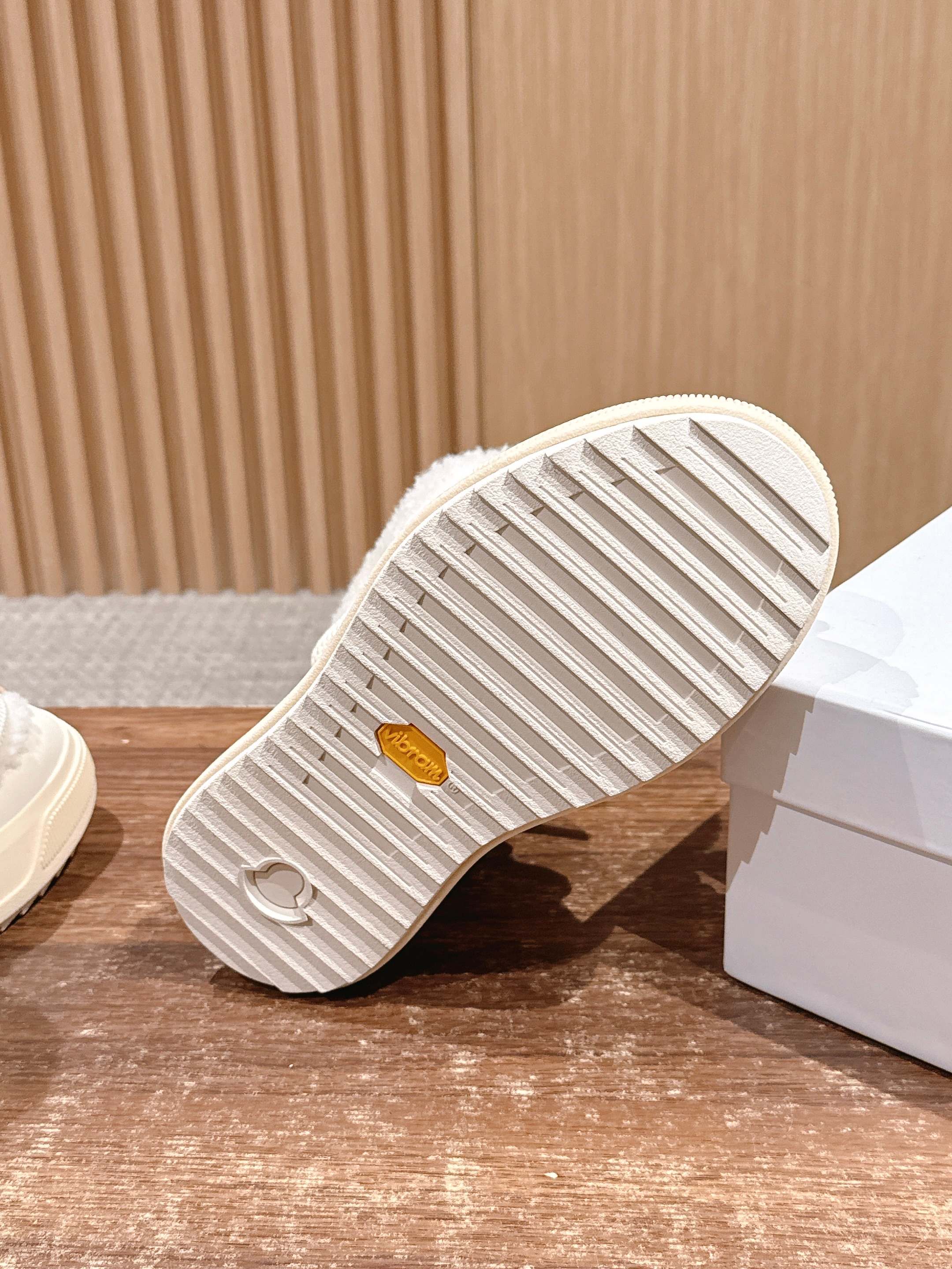 Moncler cream boot outsole with striped tread and logo emblem