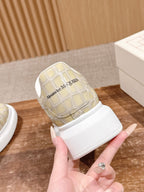 Cream alligator-embossed sneaker showing heel logo and white strap detail