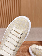 Cream alligator-embossed leather sneaker with lace-up front and textured vamp
