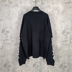 Balenciaga dark crewneck sweater, back view with sleeve logo on cuffs