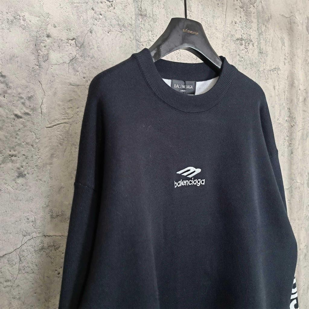 Balenciaga dark crewneck sweater, front view with centered logo on chest