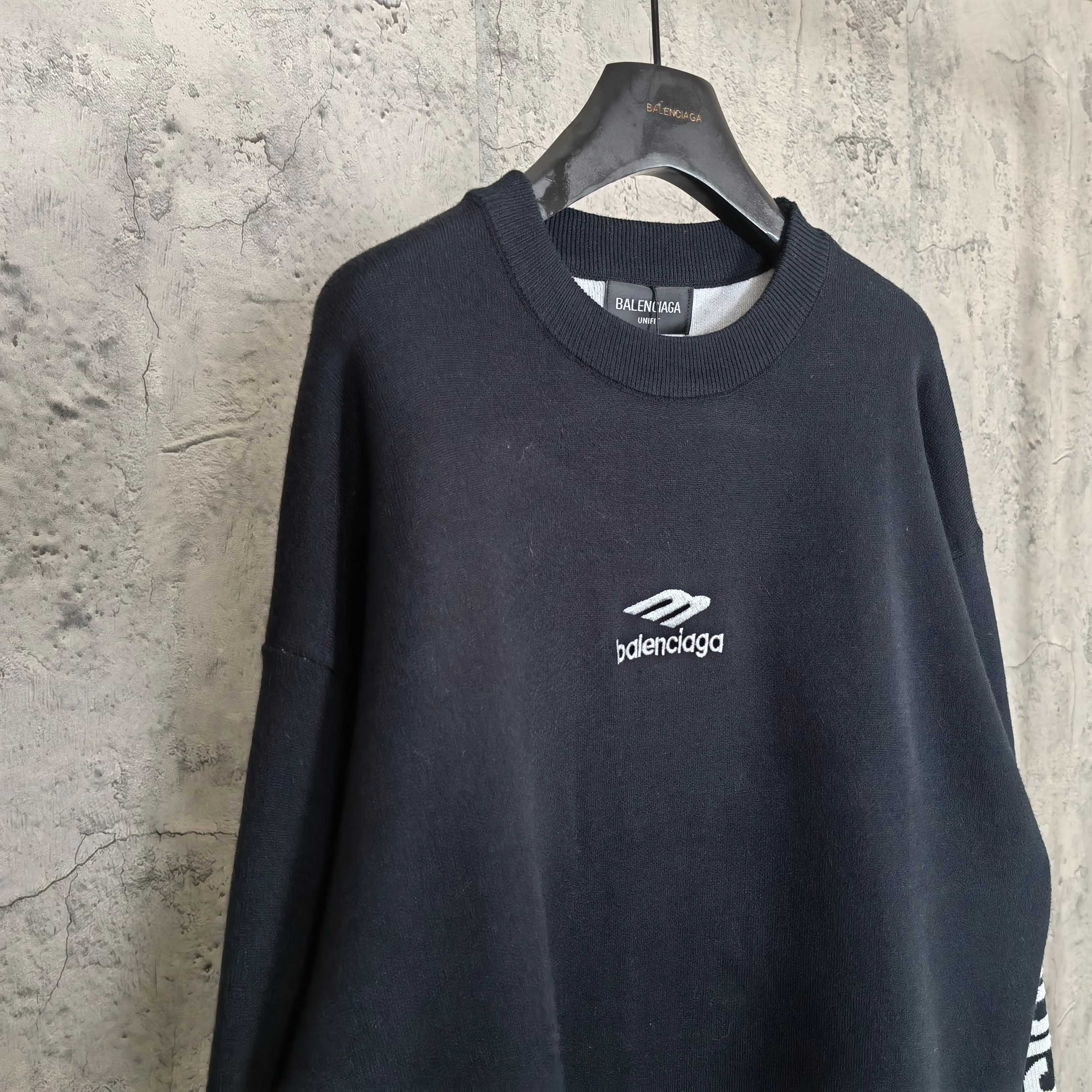 Balenciaga dark crewneck sweater, front view with centered logo on chest