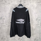 Black long-sleeve V-neck shirt with Balenciaga logo on back and sleeve stripe details.