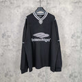 Black long-sleeve V-neck shirt with striped collar and Balenciaga front logo print.