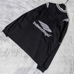Black long-sleeve V-neck shirt laid flat with centered Balenciaga logo and sleeve graphics.