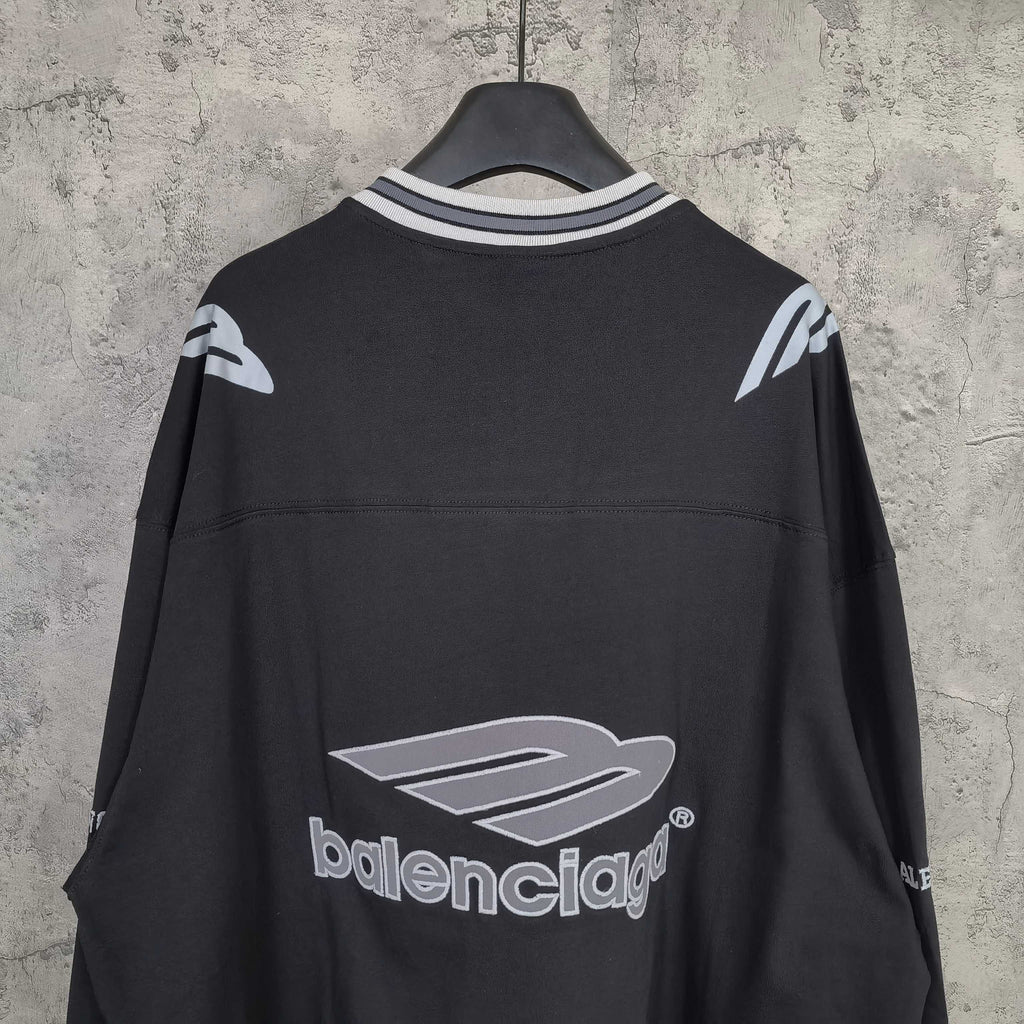 Black long-sleeve V-neck shirt back view with large Balenciaga logo and sleeve accents.