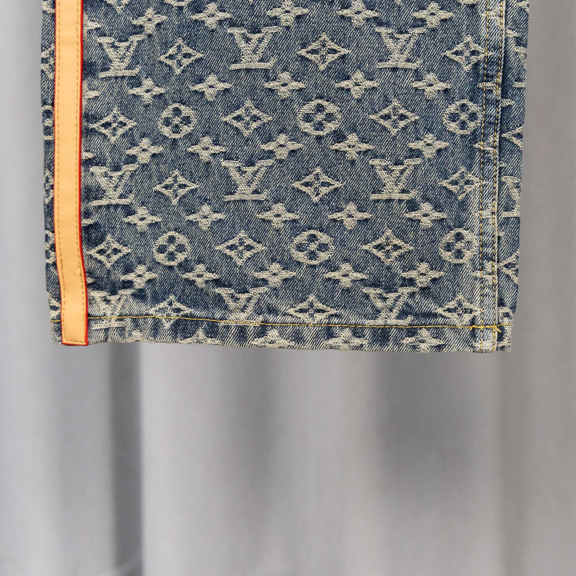 Louis Vuitton monogram denim pants pocket area with orange-trimmed edge