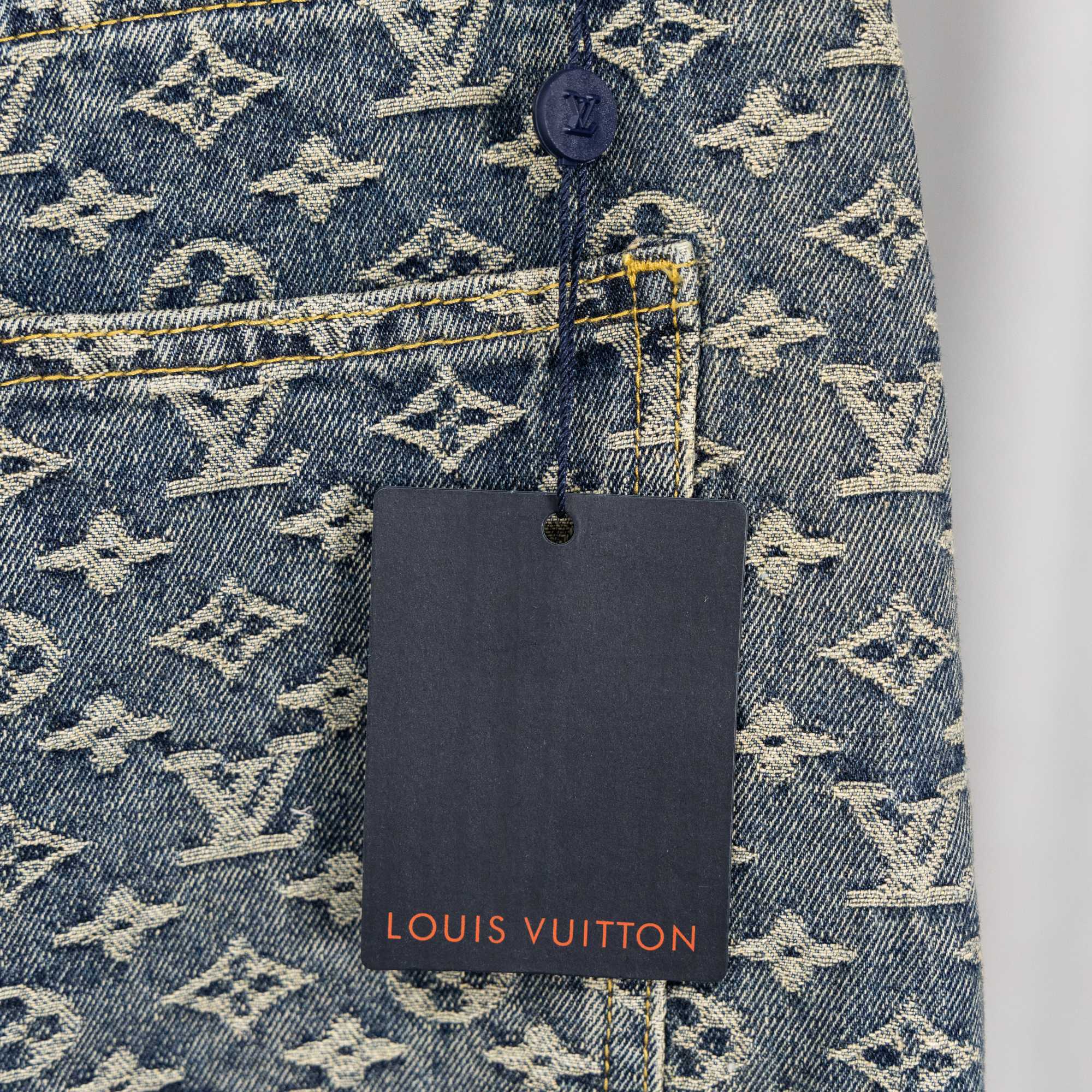 Louis Vuitton monogram denim pants with hanging brand tag near back pocket