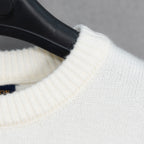 White knit sweater shoulder with ribbed collar edge