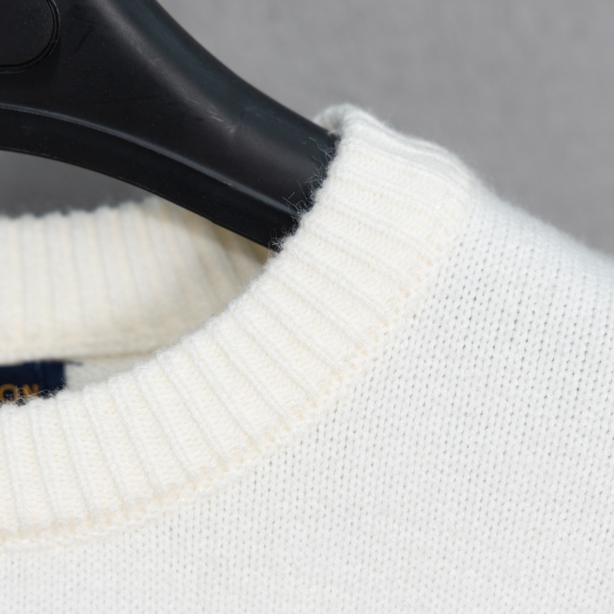 White knit sweater shoulder with ribbed collar edge