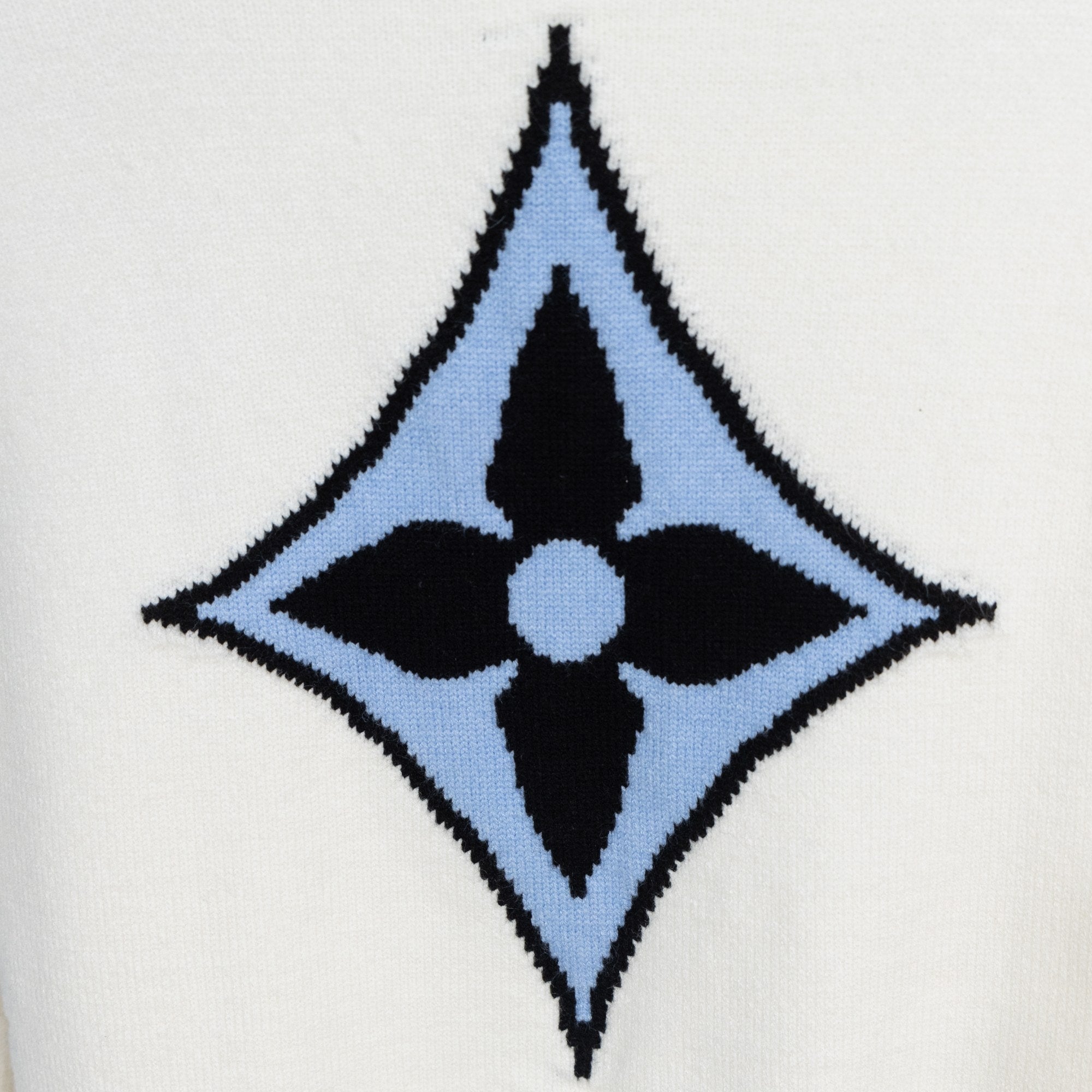 White knit sweater with blue and black diamond monogram logo on front