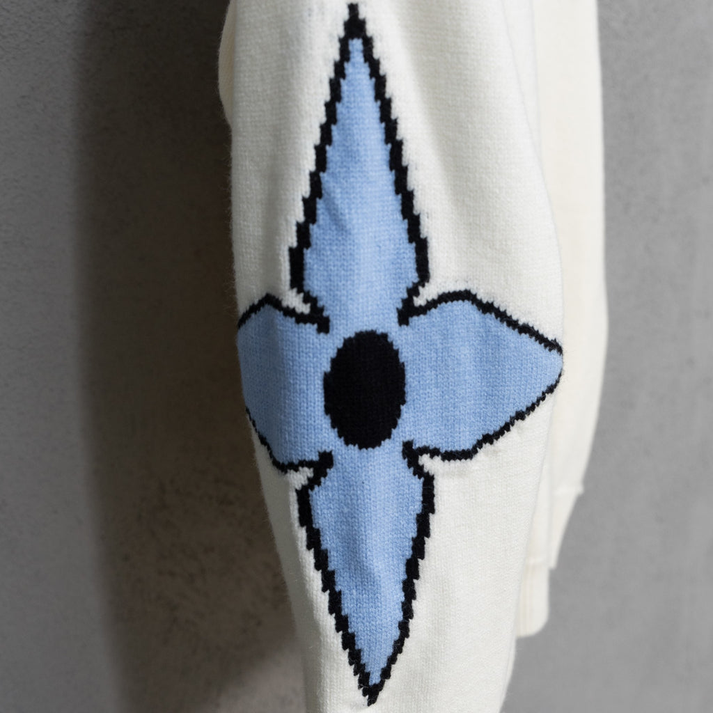 Long-sleeve knit sweater with blue and black emblem on off-white sleeve
