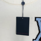 White sweater neckline with hanging Louis Vuitton tag and knit texture detail
