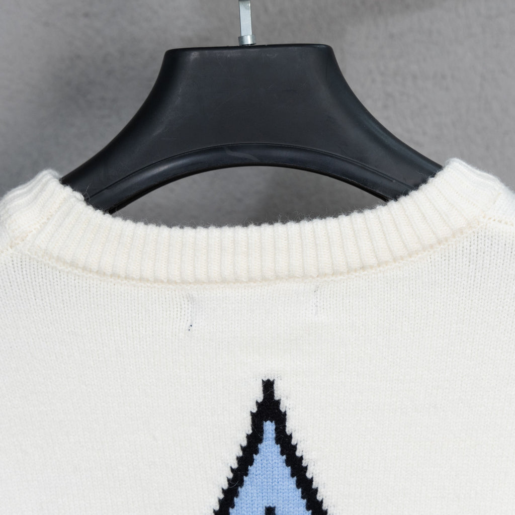 White ribbed crewneck sweater with black-and-blue logo graphic partially visible
