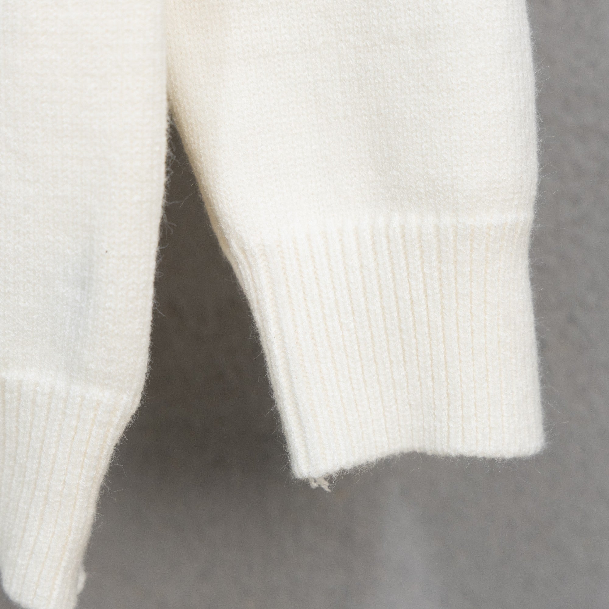 White knit sweater sleeve with ribbed cuff