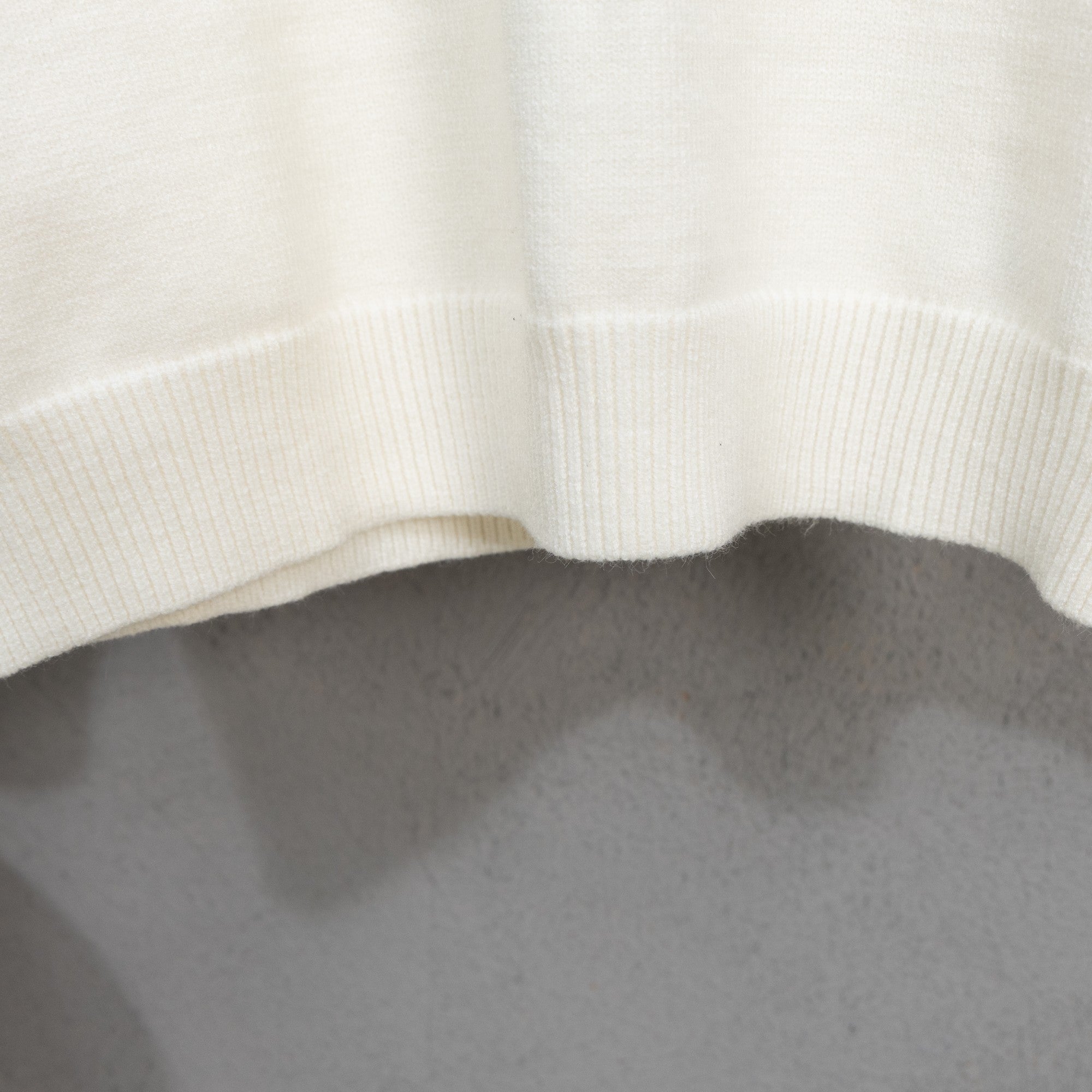 Long-sleeve knit sweater with ribbed hem on off-white fabric