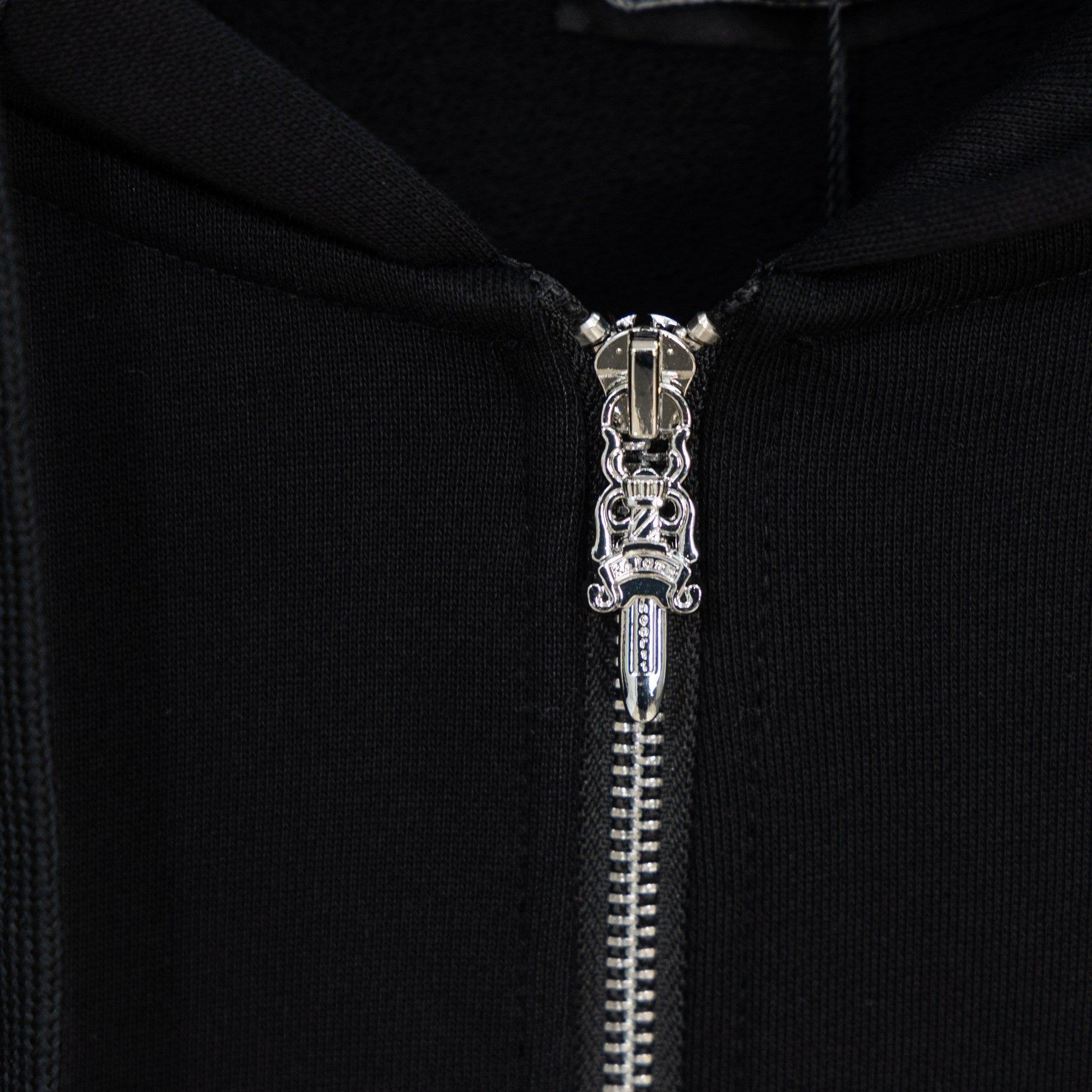Black hoodie close-up of silver zipper and metal zipper pull