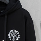 Black hoodie sleeve with pearl-studded cross-and-flower emblem on chest