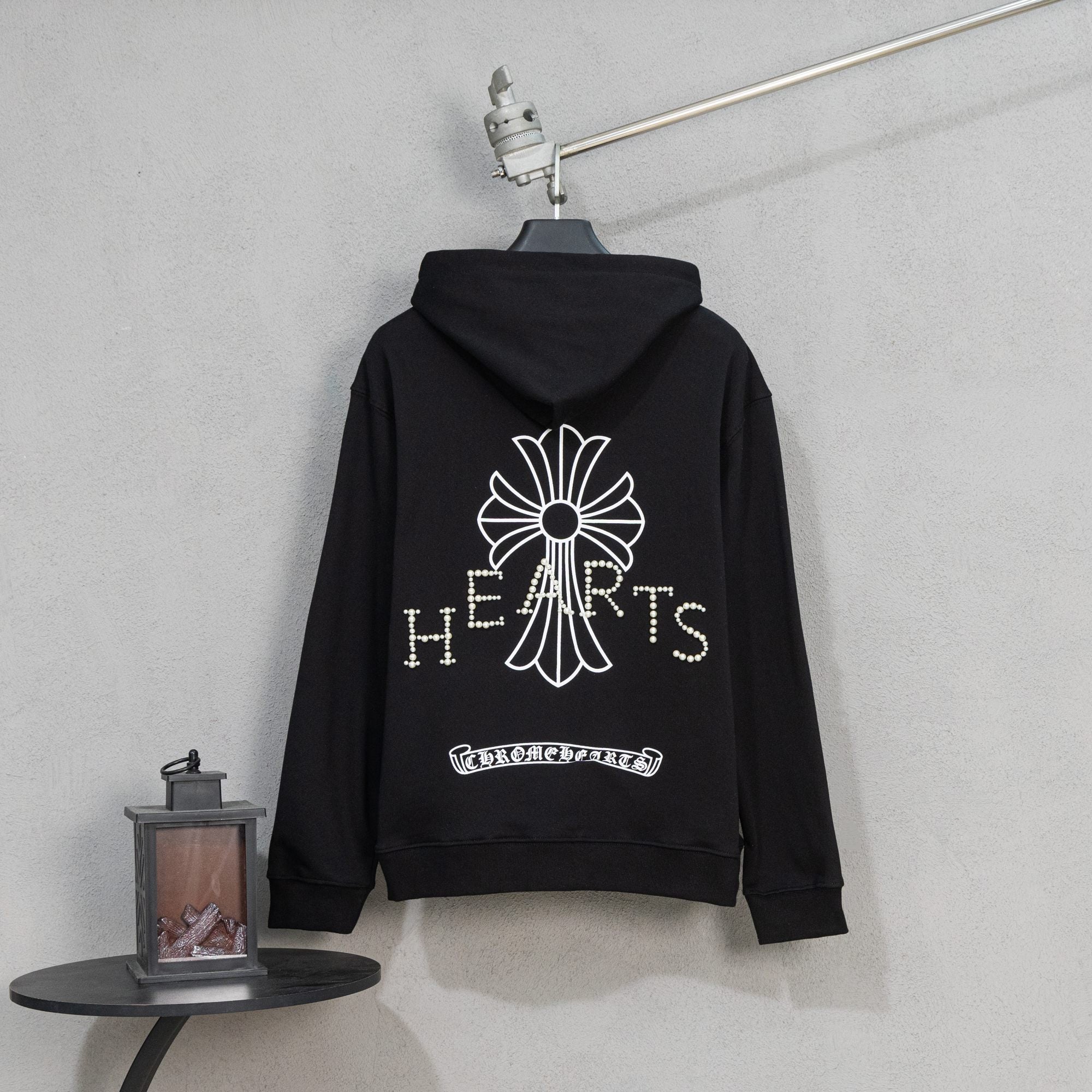 Black zip-up hoodie with back flower crest and pearl-studded lettering