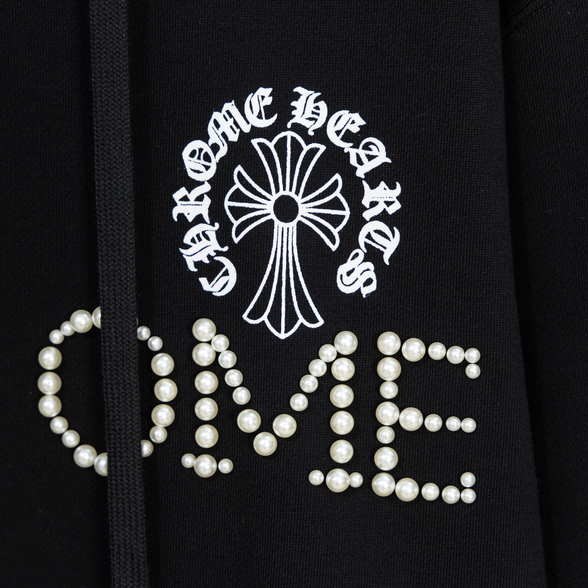 Black hoodie with pearl-studded crest and large beaded lettering on front