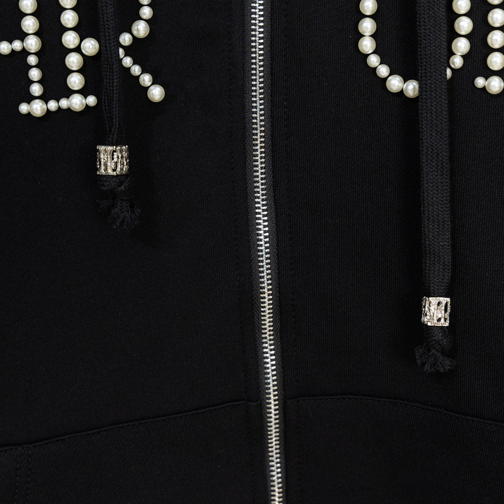 Black hoodie close-up of silver zipper and pearl beaded pocket detailing