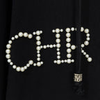 Black hoodie close-up of pearl beaded lettering with small zipper pull tassel