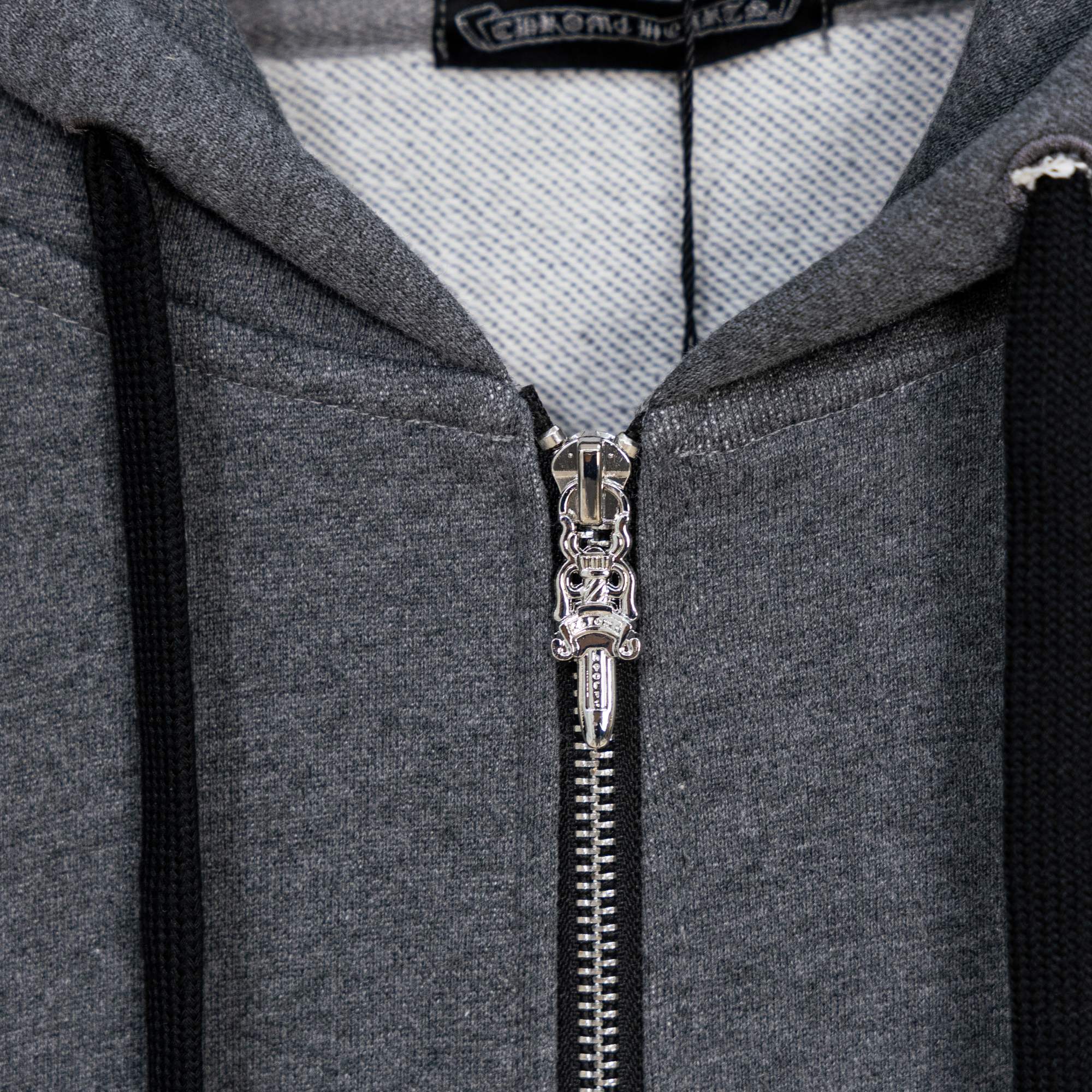 Grey zip-up hoodie close-up of silver zipper and inner hood lining