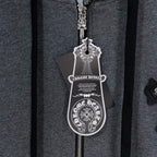 Grey hoodie front close-up showing silver zipper pull and charm tag
