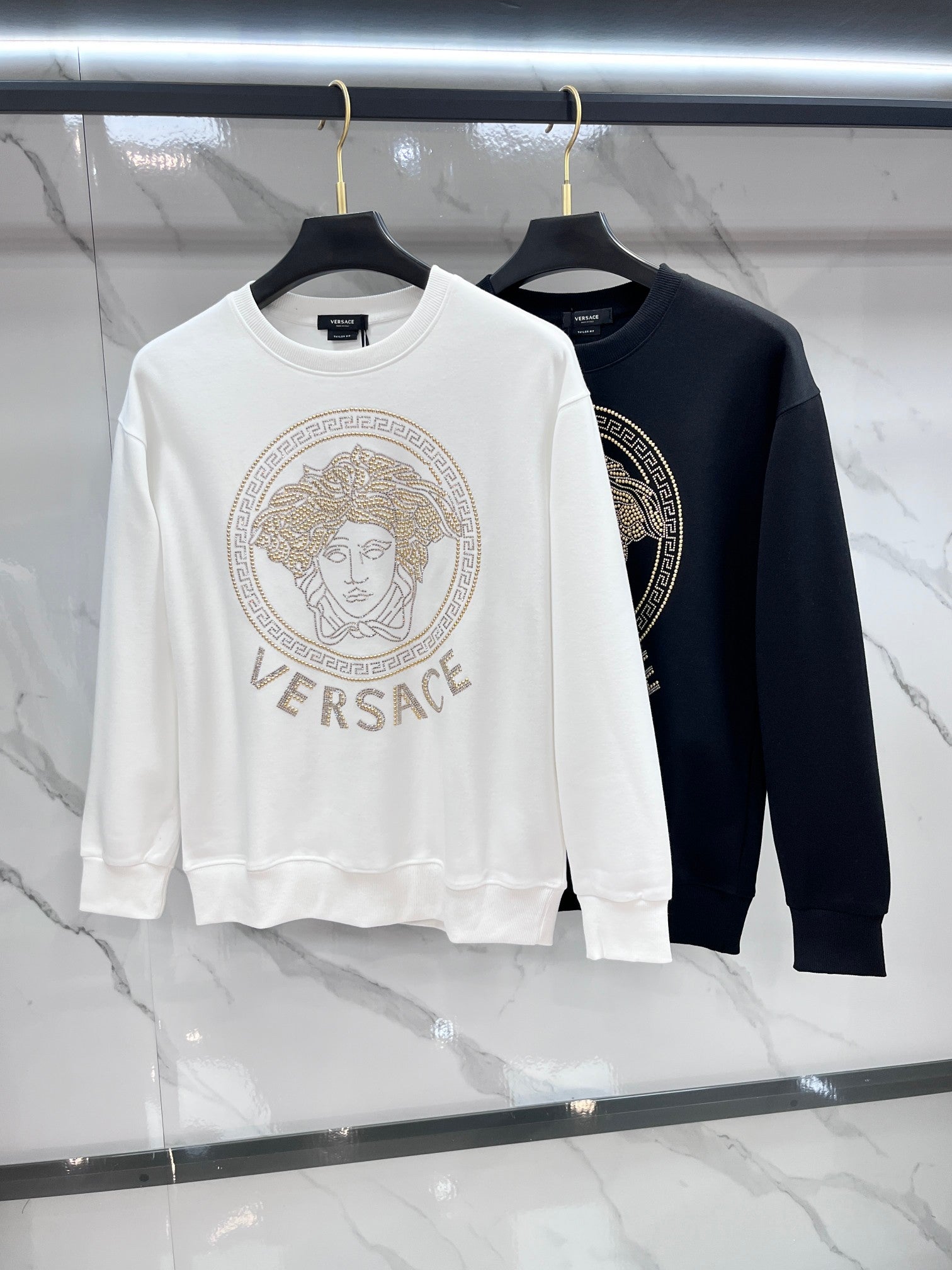 White and black crewneck sweatshirts with Versace rhinestone medallion logos