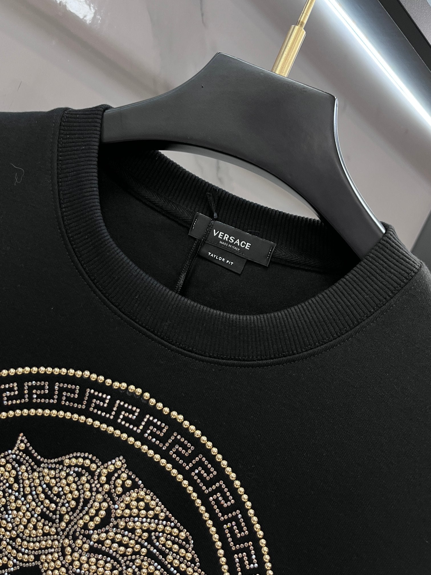 Black crewneck sweatshirt neckline with Versace label and ribbed trim