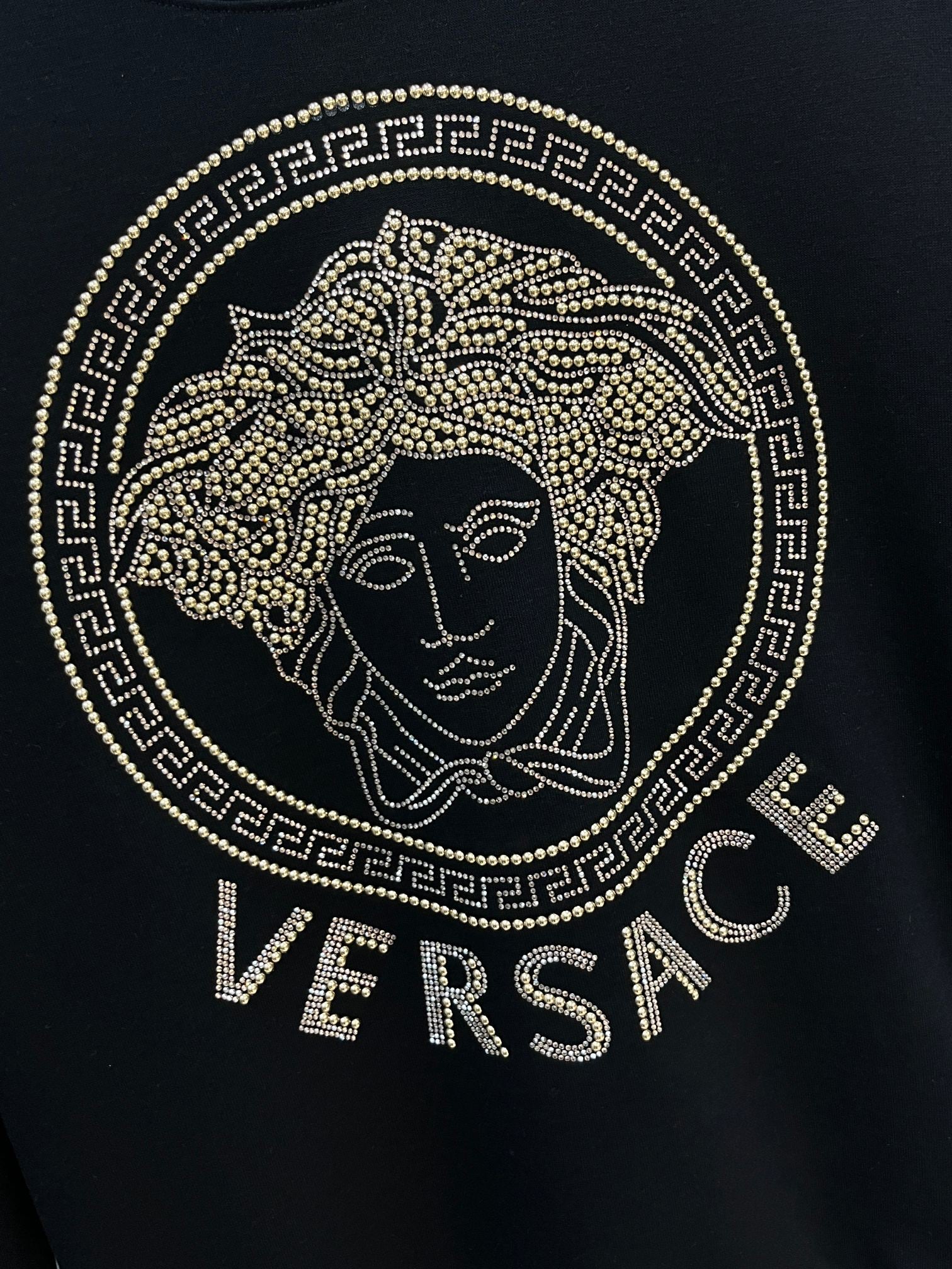 Black crewneck sweatshirt front with gold rhinestone Medusa logo and Versace text
