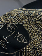 Black crewneck sweatshirt front detail with gold rhinestone face motif