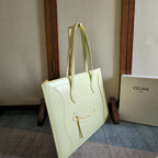 Light yellow-green leather tote bag with top handles and gold-tone hardware