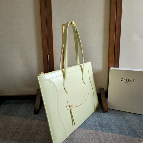 Light yellow-green leather tote bag with top handles and gold-tone hardware