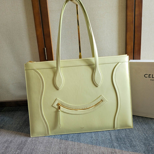 Light yellow-green leather tote bag with front zipper pocket and top handles