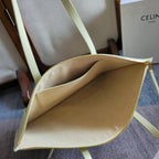 Light yellow-green leather tote bag with open interior and gold zipper trim