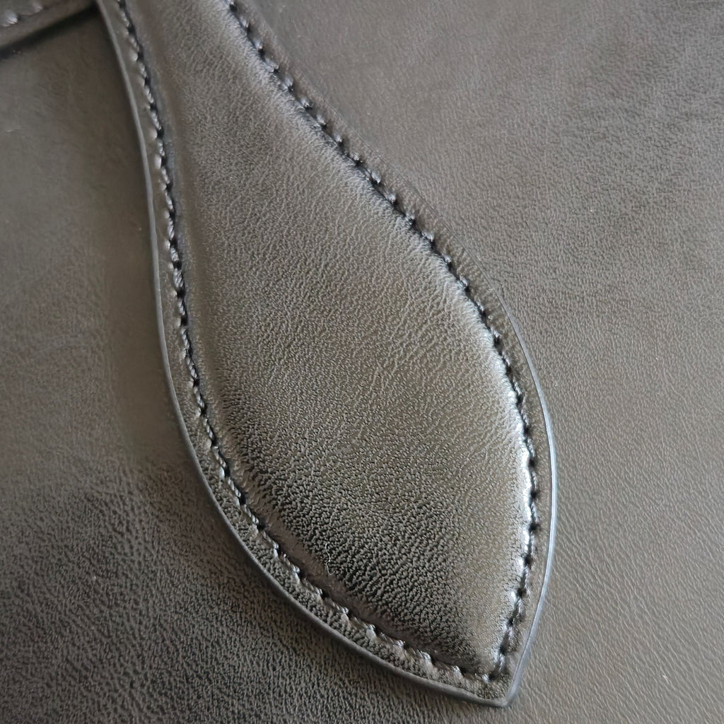 CELINE tote bag close-up of curved leather panel with stitched edge.