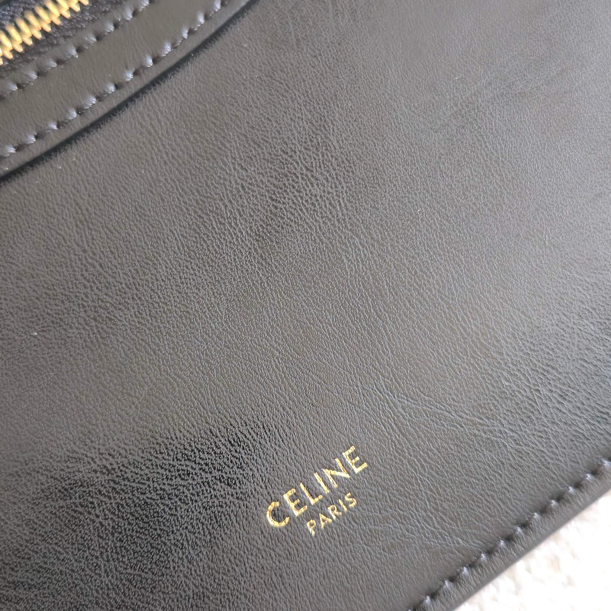 CELINE tote bag close-up of CELINE PARIS stamp on dark leather.