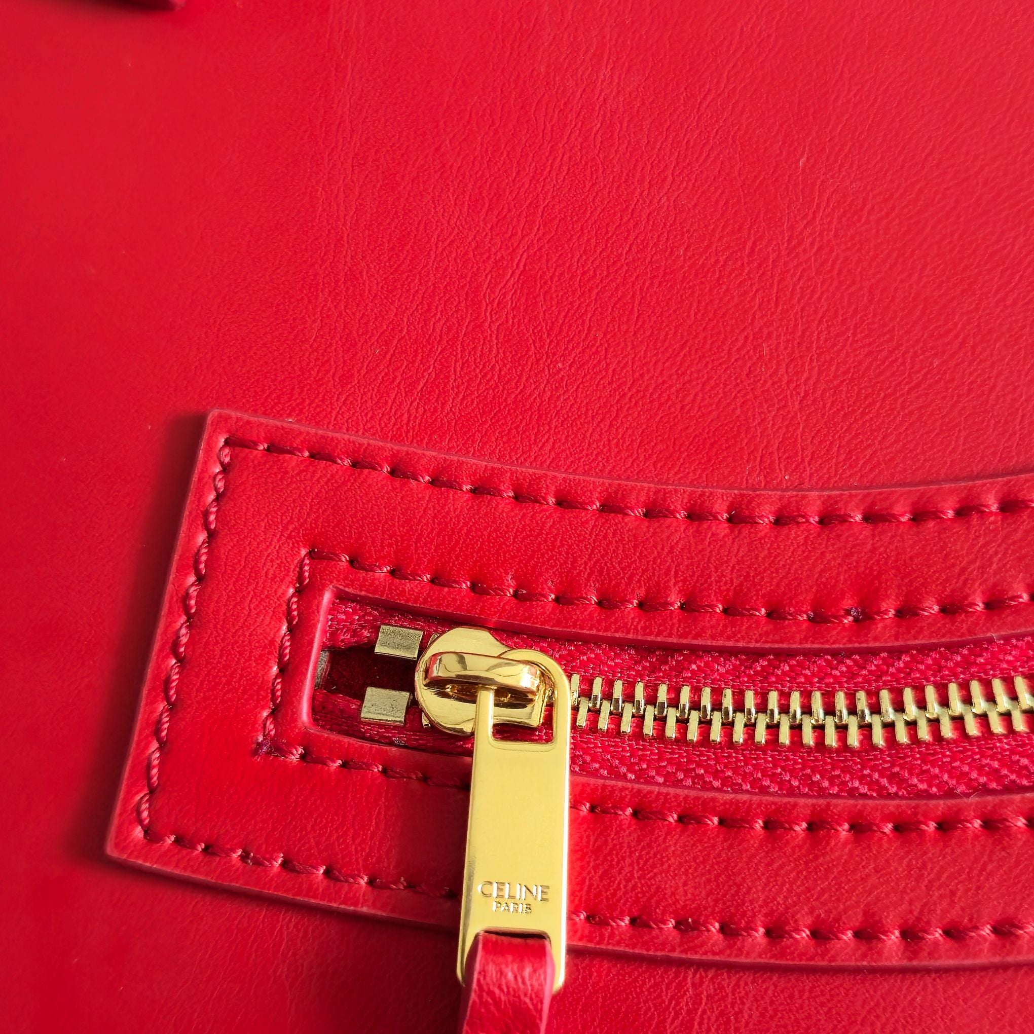 Celine gold-tone zipper pull on bright red leather with stitched edge panel