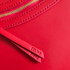 Celine leather tote close-up showing gold zipper pull and embossed logo tab