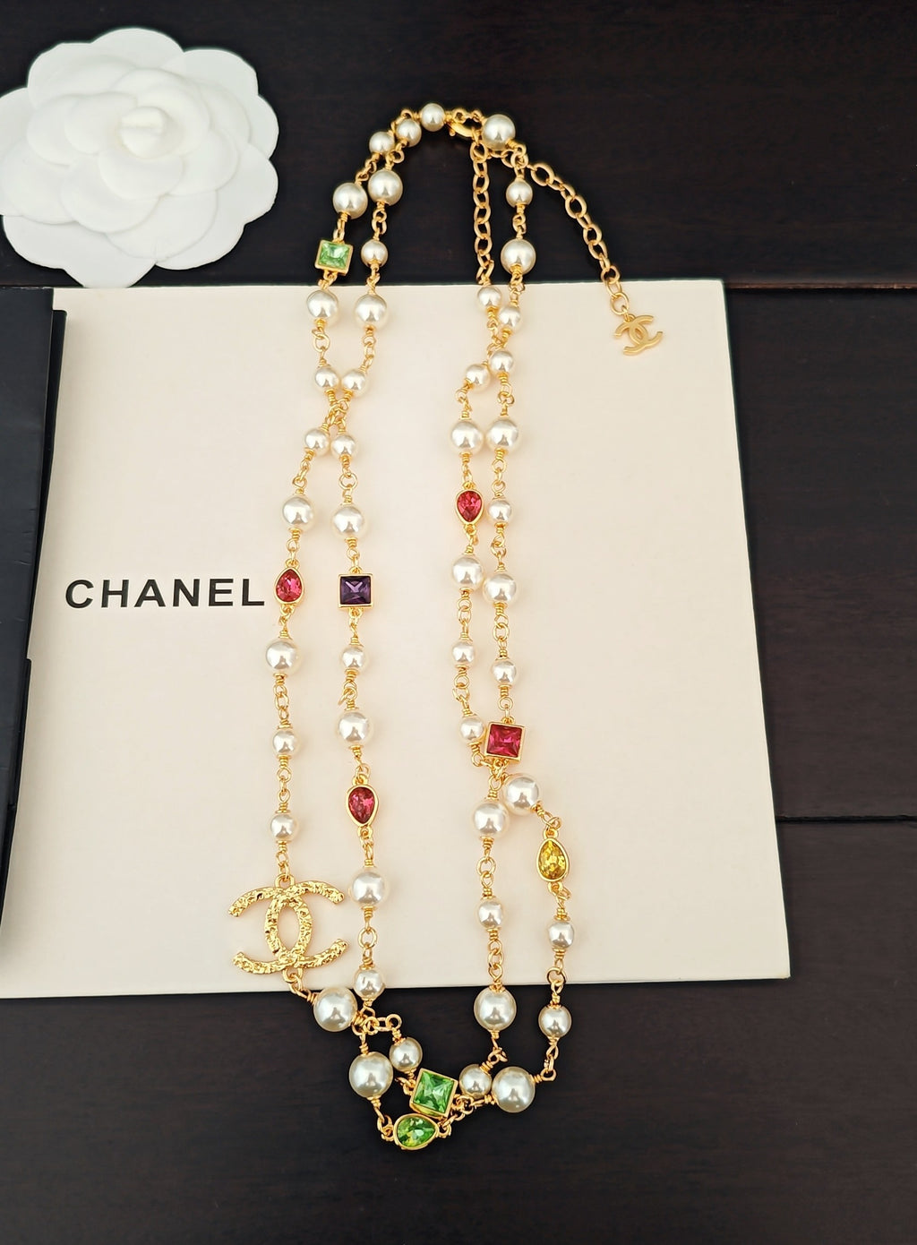 Gold-tone charm necklace set with pearl beads, dangling drops, and colorful stones